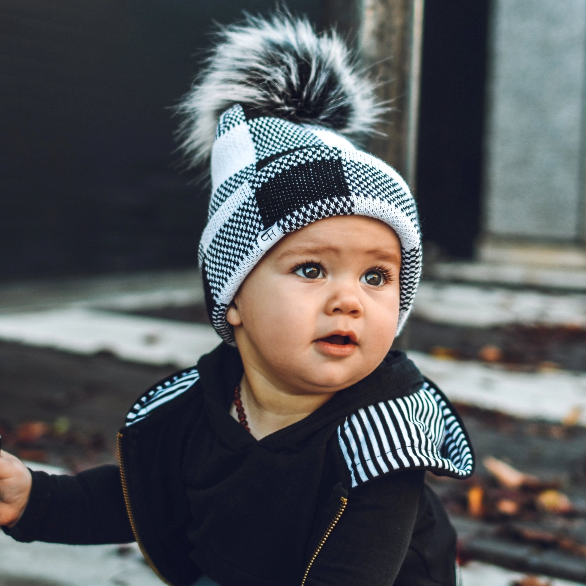 Image of a baby wearing the Black and White Plaid Beanie, a kid’s beanie from George Hats.
