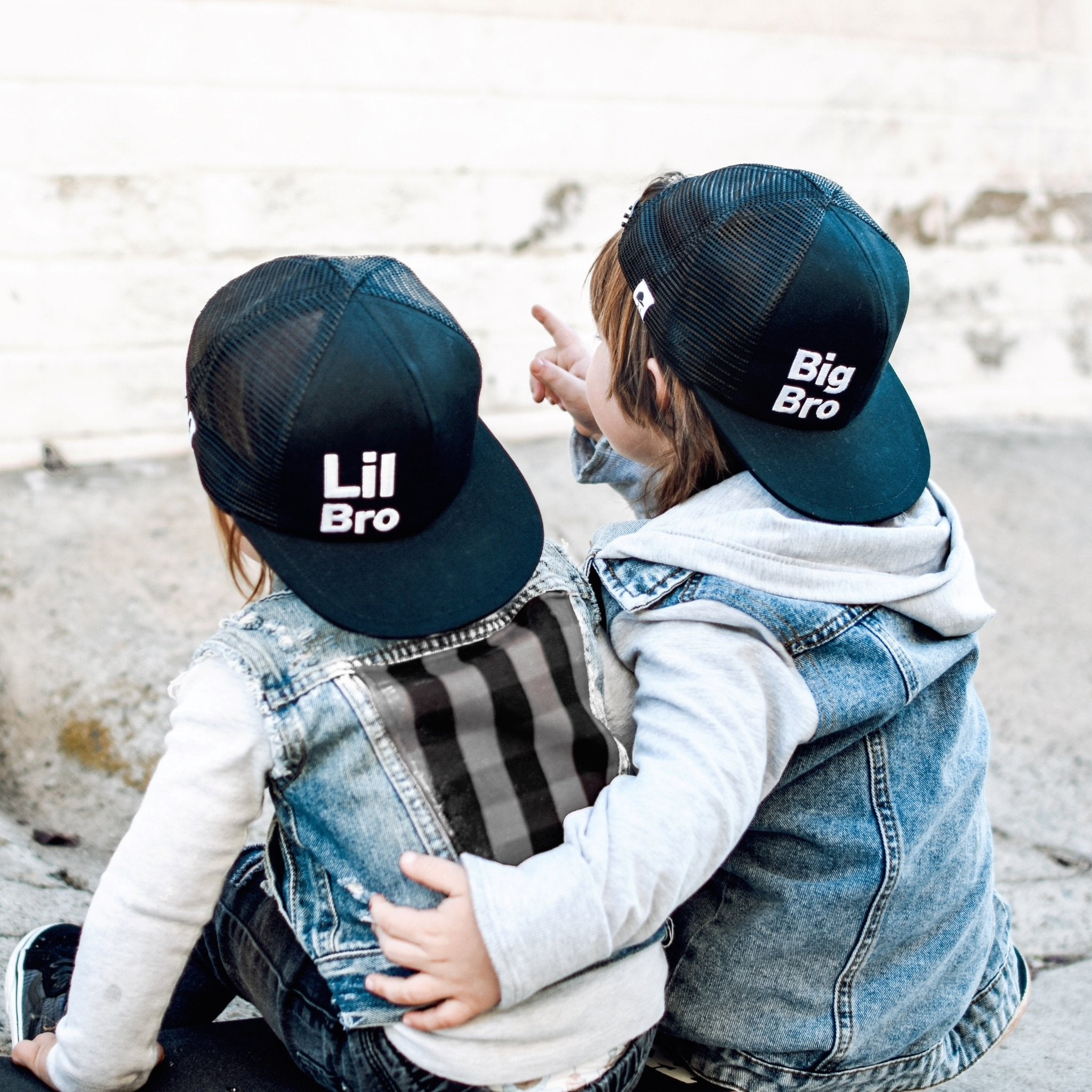 Picture of two boys in jean jackets one wearing lil bro trucker hat and the other wearing big bro trucker hat