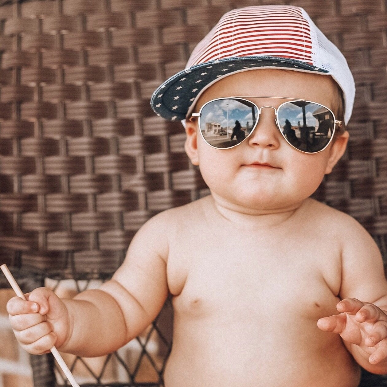 An image of a child in a patriotic trucker hat.