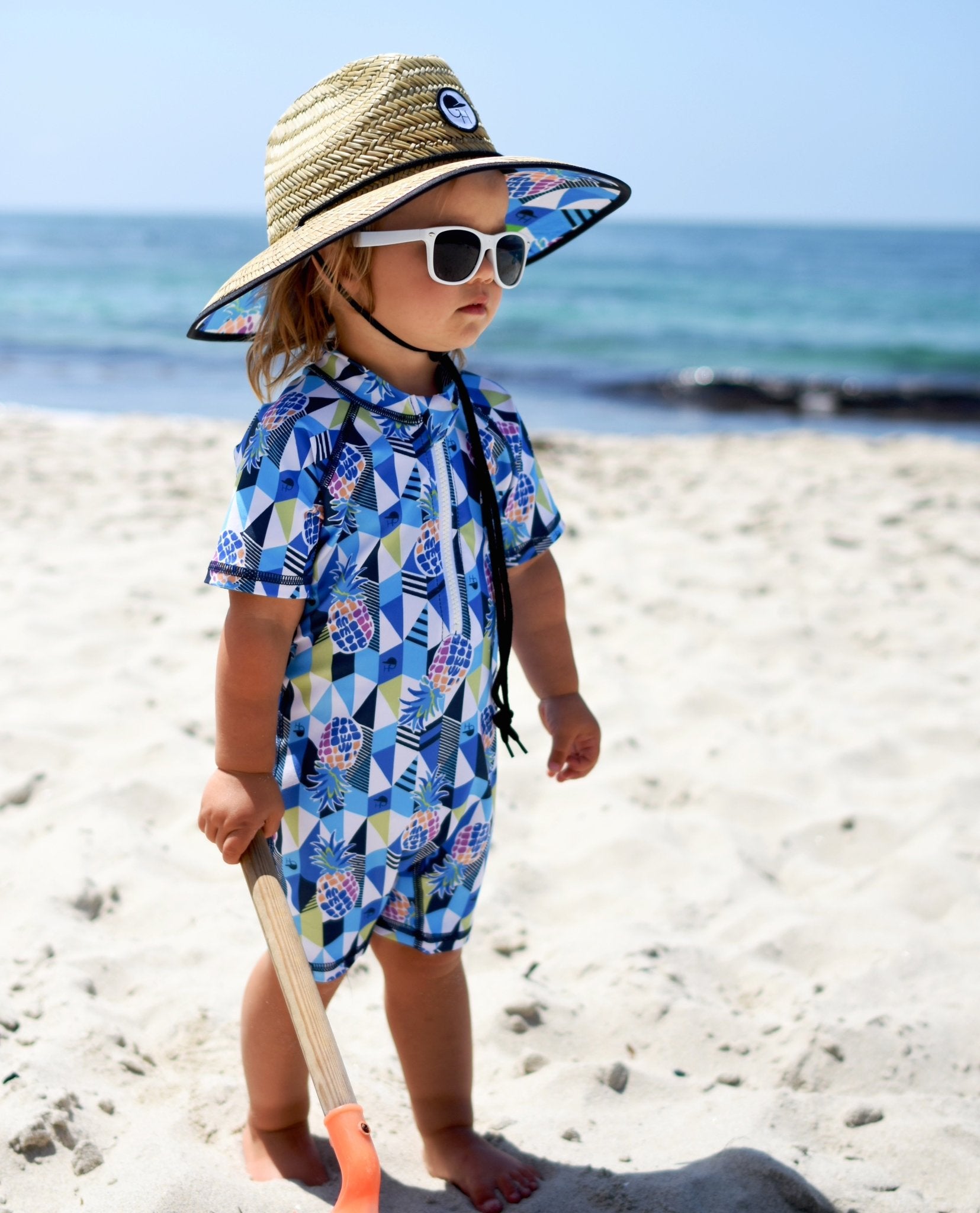 An image of a child wearing the pineapple straw hat from George Hats.