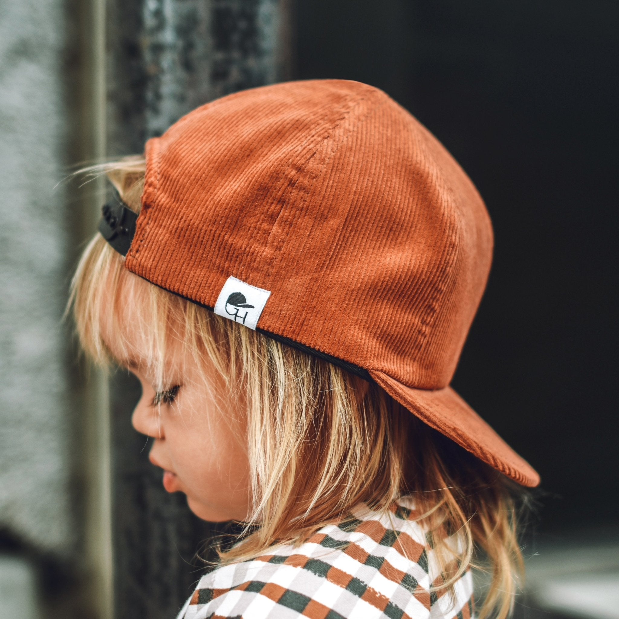 image of a boy wearing the Pumpkin Corduroy Trucker - George Hats boys truck hat