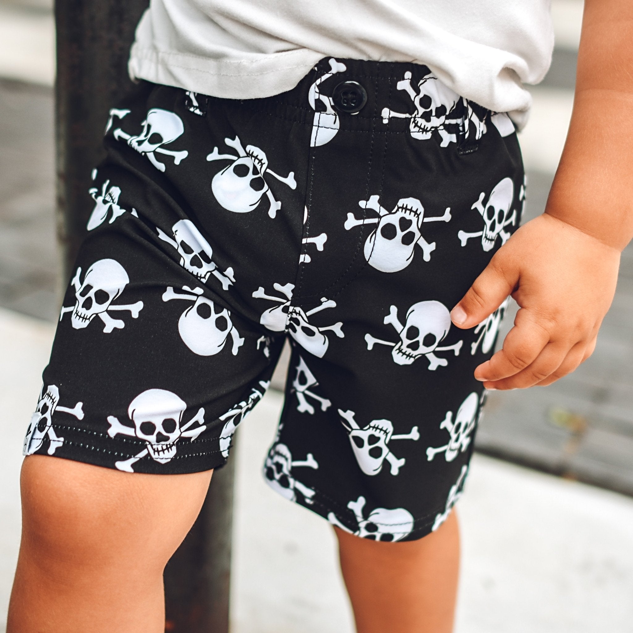 Close up image of boy's shorts with black background and white skull print -Skull Walk Shorts - George Hats