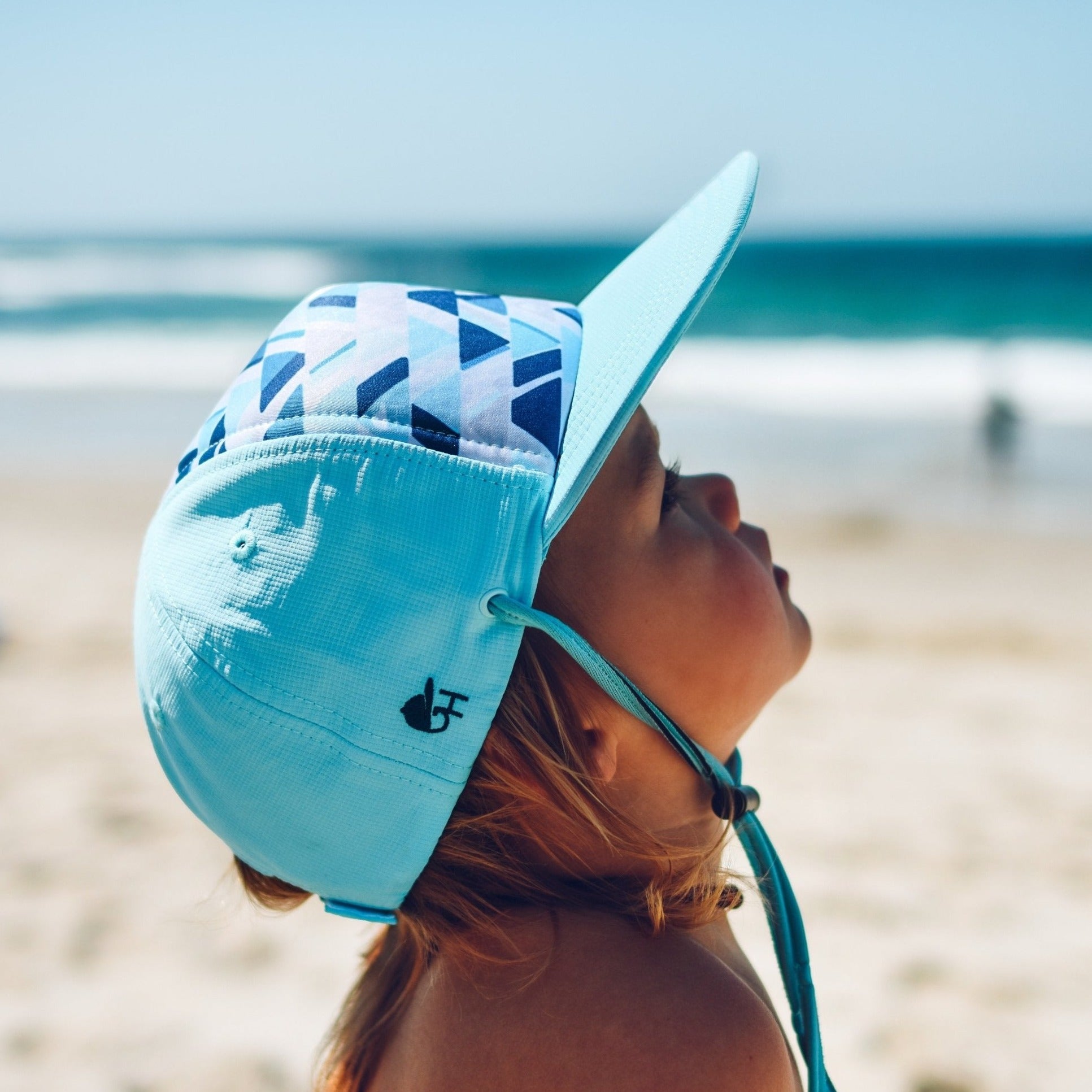 An image of a child wearing the watercolor surf hat.